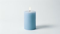 Lit light blue pillar candle isolated on white background, glowing flame, soft wax texture, calm and cozy atmosphere for home decor.