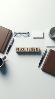 Wooden letter blocks spelling NOISE surrounded by office supplies including notebooks, pens, eyeglasses and coffee cups on white desk for workplace concept.