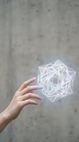 Hand reaching toward glowing geometric hologram with sacred geometry patterns floating in space against concrete wall background for futuristic design.