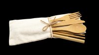 Wooden cutlery set with natural bamboo forks, knives, and spoons bundled in cream linen pouch with twine. Isolated on transparent background, ready for eco-friendly product design, t-shirt graphics, and print-on-demand applications.