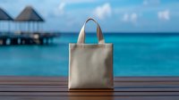 Beige canvas tote bag mockup on wooden deck with tropical ocean and overwater bungalows background for branding and design projects.