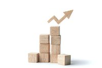 Wooden blocks stacked in ascending formation with upward trending arrow, symbolizing business growth, success, and progressive development.
