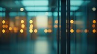 Blurred urban night scene through glass window with soft turquoise and orange bokeh lights creating dreamy atmospheric mood. Modern minimalist composition for backgrounds.
