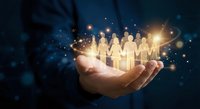 Human hands holding glowing paper cutout figures representing teamwork, leadership and community connection with magical light effects on dark background.