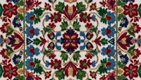 Traditional folk art embroidery pattern with colorful floral motifs on cream background. Ornate textile design featuring red, blue, green blooms in symmetrical layout.