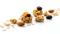Homemade granola energy balls with nuts, dried fruits and oats on white background. Healthy snack food for fitness and diet nutrition lifestyle.