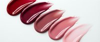 Glossy lipstick swatches in burgundy to nude pink gradient on white background for beauty and cosmetics marketing materials.