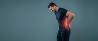 Athletic man experiencing lower back pain with red highlight showing injury area for medical and healthcare concepts.