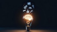 Glowing light bulb with floating business icons representing innovation, creativity and entrepreneurship concepts for marketing materials.