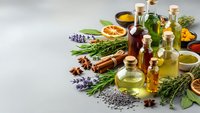 Natural essential oils in glass bottles with fresh herbs, spices and aromatherapy ingredients for wellness, spa treatments and holistic healing practices.
