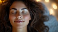Young woman with closed eyes and peaceful expression relaxing in warm golden light. Serene moment of meditation and tranquility for wellness concepts.