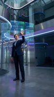 Professional businessman interacting with futuristic holographic interface displaying data analytics and digital charts in modern corporate office environment.
