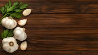 Fresh whole garlic bulbs and cloves with green parsley leaves arranged on dark wooden rustic background with copy space for text or design.