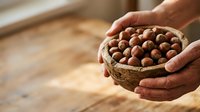Hands holding woven basket filled with raw chickpeas on wooden surface, suitable for food, agriculture, cooking, and nutrition content.