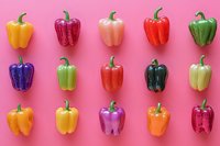 Colorful bell peppers in various hues arranged in rows on vibrant pink background. Fresh produce flat lay composition for food, nutrition, cooking, and healthy eating concepts.