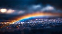 Magical rainbow arc glowing over sparkling water drops with dramatic stormy clouds and bokeh light effects creating atmospheric nature macro photography.