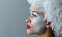 Young African American woman with white curly afro hairstyle and bright pink lipstick in profile view against gray background, artistic beauty portrait with pale makeup.