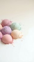 Colorful bath bombs in pastel shades scattered on white surface with powder residue for spa and wellness relaxation concepts.