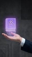 Businessman hand holding glowing purple legal book with gavel icon representing law services, legal consultation and justice system in modern office.