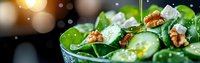 Fresh spinach salad with cucumber slices, walnuts and feta cheese drizzled with olive oil on dark background with warm bokeh lights.