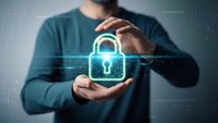 Professional man in blue shirt protecting glowing digital padlock with hands representing cybersecurity data protection and online safety concepts.
