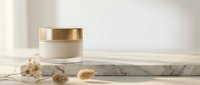 Luxury skincare cream jar with golden cap on marble surface with dried flowers for premium beauty and cosmetic product packaging design.
