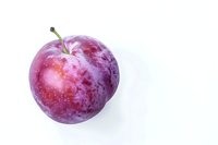 Fresh ripe purple plum with water droplets isolated on white background, perfect for food packaging, healthy eating promotion and culinary designs.