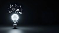 Glowing lightbulb with brain filament and renewable energy icons above on dark background representing sustainable innovation and green technology solutions.