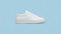 White minimalist leather sneaker on light blue background, side view. Clean casual footwear for fashion, lifestyle, and retail concepts.