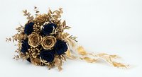 Elegant bridal bouquet with navy blue and gold paper flowers, dried foliage and satin ribbons on white background for wedding design and decoration.