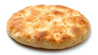 Fresh baked round flatbread with golden brown crust and soft texture isolated on white background, ready for menu design and food packaging.