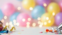 Colorful party celebration background with confetti, streamers and bokeh lights creating festive atmosphere for birthday or holiday events.