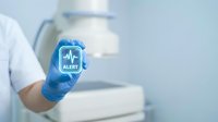 Medical professional wearing blue latex glove holding smartphone displaying health alert notification with heartbeat pulse icon on screen in clinical laboratory setting.