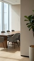 Modern conference room with wooden table and gray chairs in contemporary office space with large windows and natural light for business meetings.