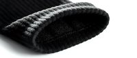 Black knitted winter beanie hat with fleece lining and ribbed cuff detail, close-up macro shot on white background.