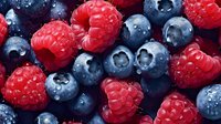 Fresh ripe raspberries and blueberries with water drops macro background. Natural organic berries closeup texture for healthy eating concept.