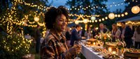 Young African American woman enjoying outdoor evening party with string lights and wine glass celebrating social gathering with friends in background.