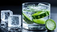 Fresh cucumber slices in sparkling water with ice cubes and bubbles on dark background, refreshing summer drink macro photography.