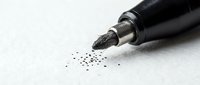 Black marker pen with ink splatter on white paper surface, suitable for art, design, and creative projects.