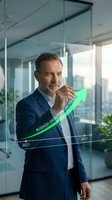 Confident middle-aged Caucasian businessman in navy suit drawing upward growth arrow on glass in modern office, representing success and financial progress.