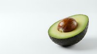 Fresh ripe avocado half with pit on clean white background, healthy organic fruit for cooking, nutrition and diet concepts.