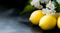 Fresh yellow lemons with white jasmine blossoms on dark background, selective focus. Natural organic citrus fruit composition for healthy lifestyle.