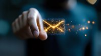Glowing digital envelope with sparkles held between fingers against dark background, representing electronic mail communication and digital messaging technology.