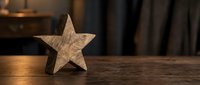 Wooden star decoration on rustic table surface with warm lighting and blurred background for home decor and crafting projects.