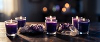 Purple candles in glass holders with amethyst crystals create mystical ambiance for meditation, spiritual practices, and relaxation rituals.