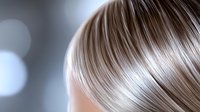 Close up view of platinum blonde hair with soft highlights and natural waves against blurred bokeh background, showing healthy shine and smooth texture.