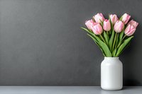 Fresh pink tulips in white ceramic vase against dark gray textured wall on light surface, minimalist spring floral arrangement with copy space for text.