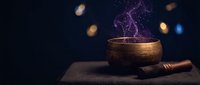 Mystical wooden singing bowl with purple smoke and magical sparkles on ancient book for meditation and spiritual healing practices.
