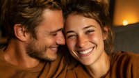 Happy young couple embracing and smiling together in warm cozy home setting with soft lighting creating intimate romantic atmosphere for relationships.