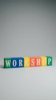 Colorful wooden alphabet blocks spelling WORKSHOP on a light gray background, great for education, training, and business event concepts.